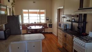 a kitchen with a stove and a table in it at Hillocks Drive in Marion Bay