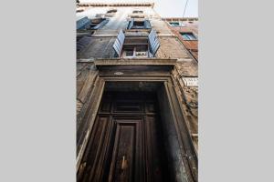 a building with a wooden door with a window at Appartamento Cassiano Rialto in Venice