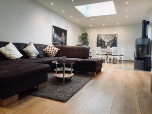 a living room with a brown couch and a table at Ferienwohnung Tulpenweg mit Kaminofen in Haiger