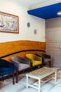 una sala de espera con 3 sillas y una mesa en Hotel Arcadia en Panaji