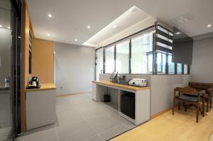 a kitchen with a counter and a table and chairs at Gijang Hound Hotel Ilgwang in Busan