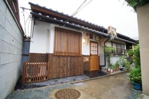 a house with a wooden fence and a gate at Inuicho Tori in Kyoto