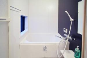 a white bathroom with a shower and a sink at Inuicho Tori in Kyoto