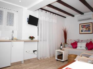 uma sala de estar branca com uma cama e um lavatório em Apartment Bonbon em Dubrovnik