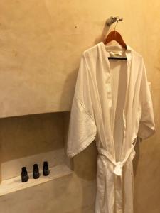 a white robe hanging on a rack in a bathroom at Villa San Antonio de Padua in Izamal