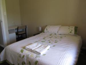 a bedroom with a bed with towels on it at Acacia Cottage in Tumbarumba