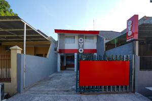 a red gate in front of a building at Super OYO Naomi Heritage in Surabaya