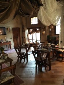 uma sala de jantar com mesas e cadeiras de madeira em Corte degli Angeli Società Agricola e Agrituristica em Busseto
