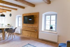 a living room with a television and a table and chairs at FarmHouse Eckartsberg im Zittauer Gebirge - Ferienwohnung mit 2 Schlafzimmern, Terrasse und WALLBOX in Mittelherwigsdorf