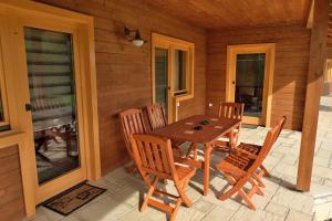 a wooden table and chairs on the porch of a cabin at Majorka Vendégház in Diósjenő
