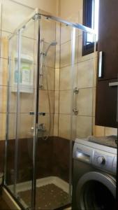 a shower in a bathroom with a washing machine at Near the beach Aparment with garden in Pervolia