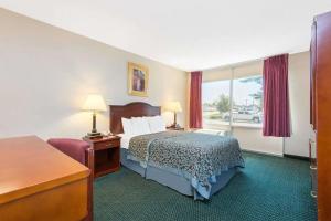 a hotel room with a bed and a window at Blue Way Inn & Suites Wichita East in Wichita