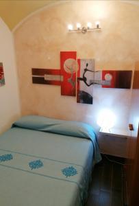 a bedroom with a bed and paintings on the wall at Le antiche mura 2 in Sassari