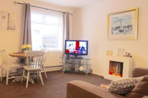 een woonkamer met een tv en een tafel en een open haard bij Shirebrook House Coventry west Midlands in Coventry