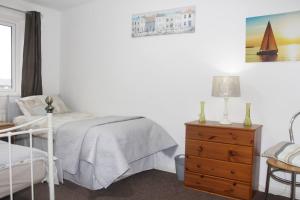 een slaapkamer met een bed en een dressoir met een lamp bij Shirebrook House Coventry west Midlands in Coventry