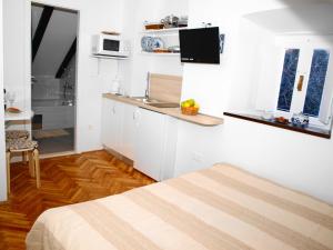 uma pequena cozinha branca com um lavatório e um micro-ondas em Apartment Bonbon em Dubrovnik