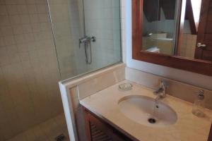 a bathroom with a sink and a shower with a mirror at Tredós, Casa adosada. Baqueira in Tredós