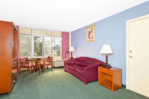 a living room with a red couch and a table at Blue Way Inn & Suites Wichita East in Wichita
