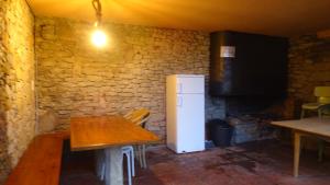 uma cozinha com uma mesa e um frigorífico num quarto em Refugi del Esquirol em Sobremunt