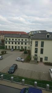 un edificio con un coche aparcado en un aparcamiento en Ferienwohnung und Apartment Löbau, Stadt- und messenah, en Löbau