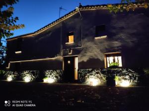 una casa con luces delante de ella por la noche en Casa Rural "Can Abres" Vilobi d`Onyar Girona en Vilobí d'Onyar