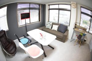 uma pequena sala de estar com um sofá e uma mesa em ロワジール岩槻201 em Iwatsuki