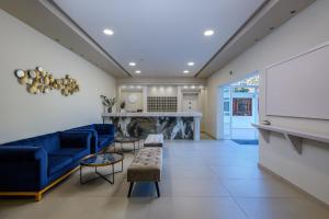 a living room with a blue couch and a fireplace at Kalimera Mare in Kardamaina