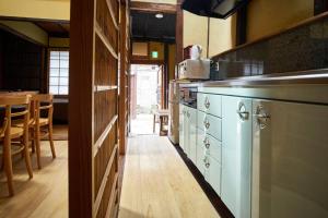 una cocina con armarios blancos y una mesa en una habitación en Koke-an, en Kioto