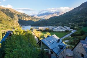 a view of a town with a river and mountains at Foratata - con piscina, familiar y muy acogedor in Sallent de Gállego