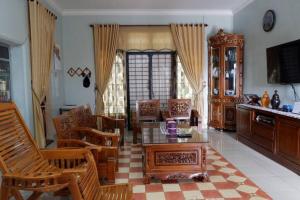 sala de estar con mesa y sillas de madera en Samba Homestay, en Kedaton