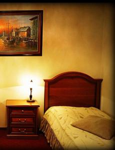 a bedroom with a bed and a nightstand with a picture at Hotel Zaodrze in Opole