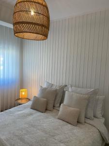 a bedroom with a large bed with pillows and a lamp at BBA Moledo - Beachfront Apartment in Moledo