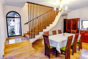 - une salle à manger avec une table, des chaises et des escaliers dans l'établissement Villa Boutique Alina, à Deva