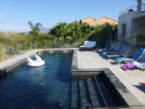 a swimming pool with an inflatable pool noodle in the water at Villa Vellutini in Calvi