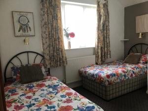 een slaapkamer met 2 bedden en een raam bij Melrose Hotel in Blackpool