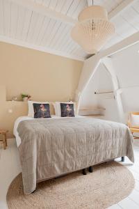 a white bedroom with a large bed with a rug at Boutique Hotel - de Stadsherberg Alphen in Alphen aan den Rijn