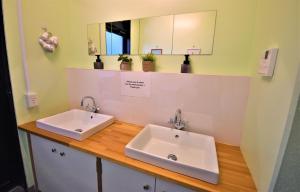 a bathroom with two sinks on a wooden counter at Hakone Guest House gaku. in Hakone
