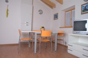 ein Esszimmer mit einem Tisch mit Stühlen und einem TV in der Unterkunft Windshouse in Nago-Torbole