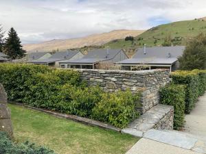 a stone retaining wall in front of a house at Cardrona Valley Studio (17) in Cardrona