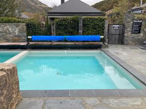una piscina con cojines azules en un patio en Cardrona Valley Studio (17), en Cardrona