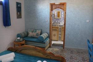 a living room with a couch and a mirror at Riad Les Chtis D'Agadir in Agadir
