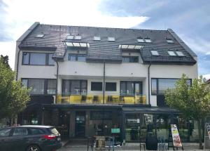 a large white building with a black roof at Rubin Anett Apartman Sárvár in Sárvár