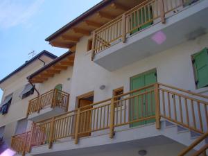 un edificio con puertas verdes y balcones de madera en Windshouse, en Nago-Torbole
