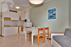 - une cuisine et une salle à manger avec une table et des chaises dans l'établissement Condominio Cristallo, à Lignano Sabbiadoro