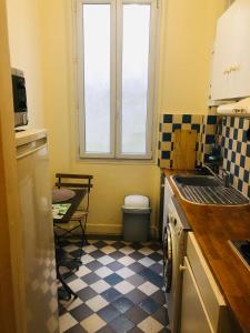 uma pequena cozinha com piso em xadrez em Appartement Porte De Clichy em Clichy