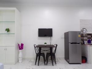 a small kitchen with a table and a refrigerator at Ananta Aster in Phnom Penh