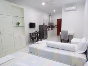 a white room with a bed and a kitchen at Ananta Aster in Phnom Penh