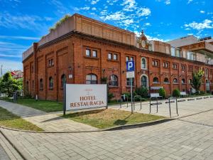 a large brick building with a sign in front of it at Antonińska Hotel & Apartamenty in Leszno