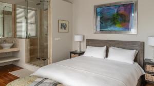 a bedroom with a bed and a shower and a sink at The Majestic Apartments in Kalk Bay