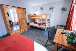 a room with two bunk beds and a desk and a table at Chalet de Lanza in Abriès